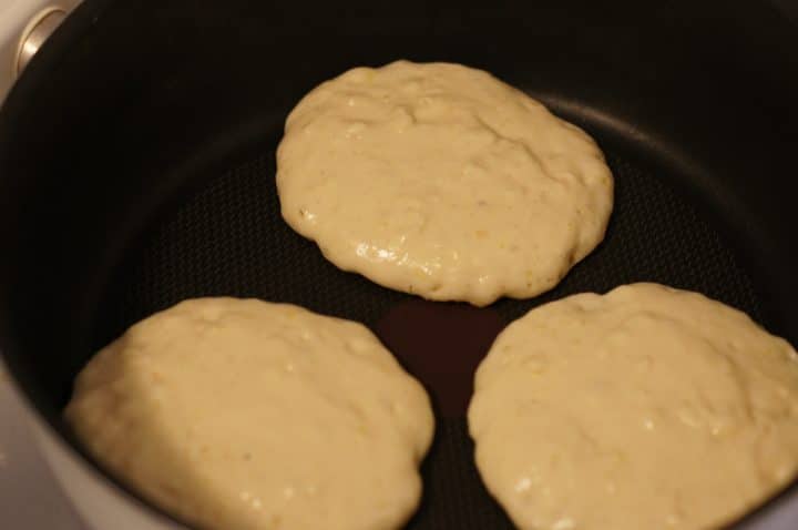 3 pancakes being cooked in one pan. They are all rising high.