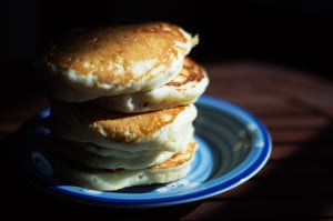 Five fluffy pancakes stacked under dark moody lighting