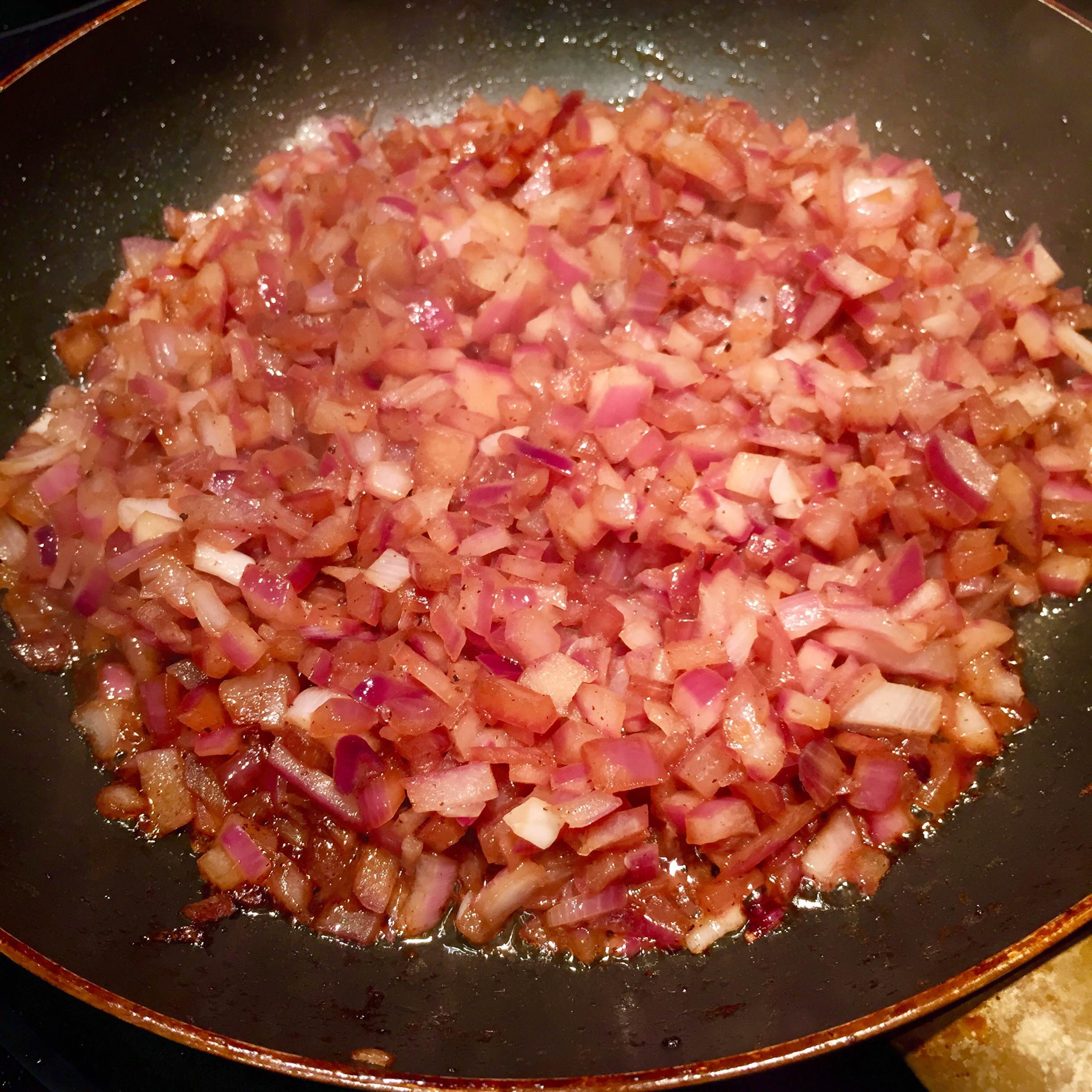 Onions being cooked in a pan. 