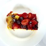 Overhead photo of Baked French Toast with berries on top on a plate.