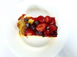 Overhead photo of Baked French Toast with berries on top on a plate.