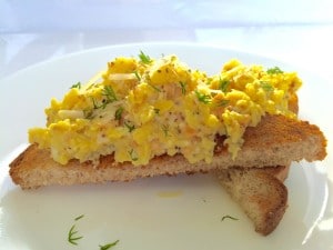 A side photo of scrambled eggs with smoked salmon on toast