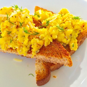 A close-up photo of scrambled eggs with smoked salmon on toast
