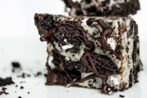 No Bake Oreo Cheesecake Bars laying on its side with crumbs around it.