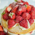 A ¾ angle shot of Victoria Sponge Cake with Balsamic Strawberries.