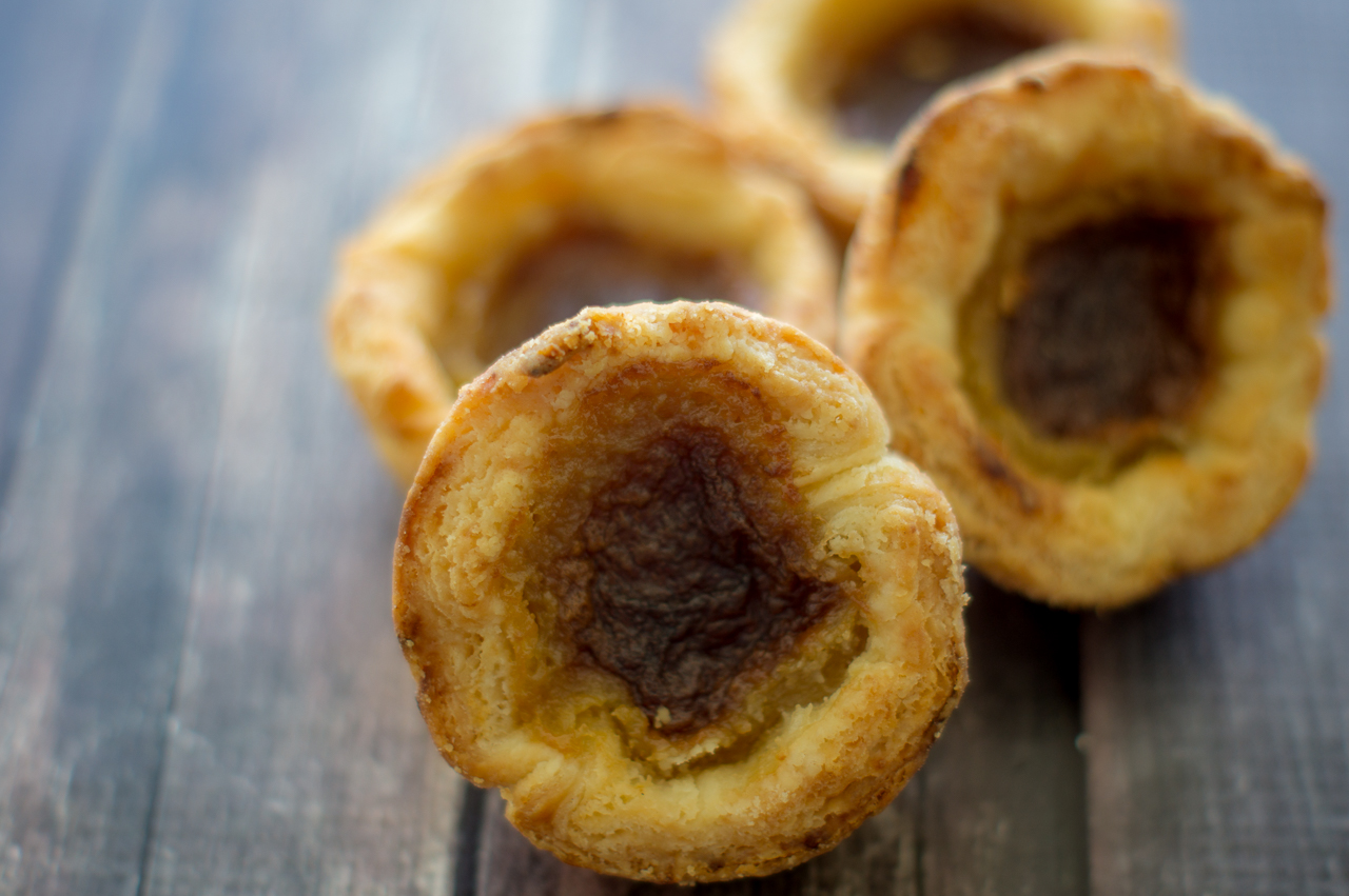 Four Canadian butter tarts placed together, with the closest propped up to by some at the back.