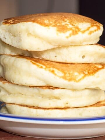 A square close up image for 5 fluffy pancakes stacked high.