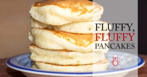 Five super fluffy pancakes stacked high on a blue plate.