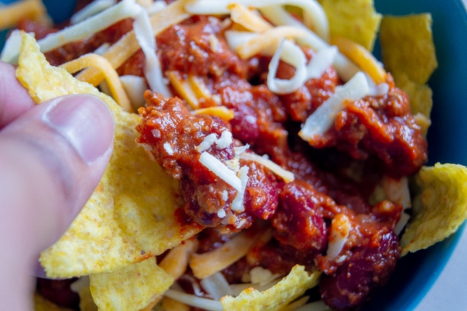 A close-up photo of Chili Con Carne scooped on to a tortilla chip.