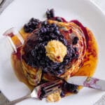 An overhead photo of the pancakes showing off the brown sugar butter atop the stack of blackberry pancakes.