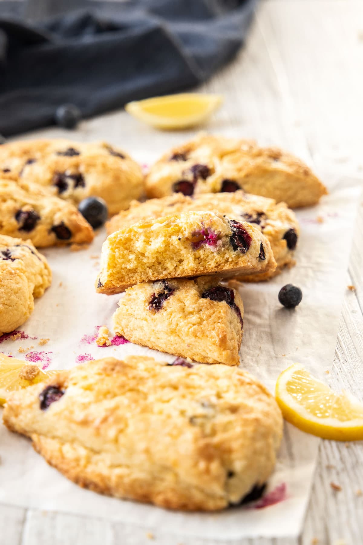 Lemon Blueberry scones on a table top with the centre scone missing a large bite.