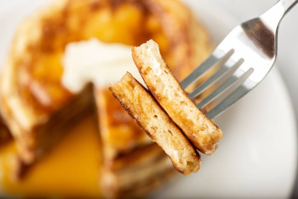 A close-up of a forkful of sour cream pancakes.