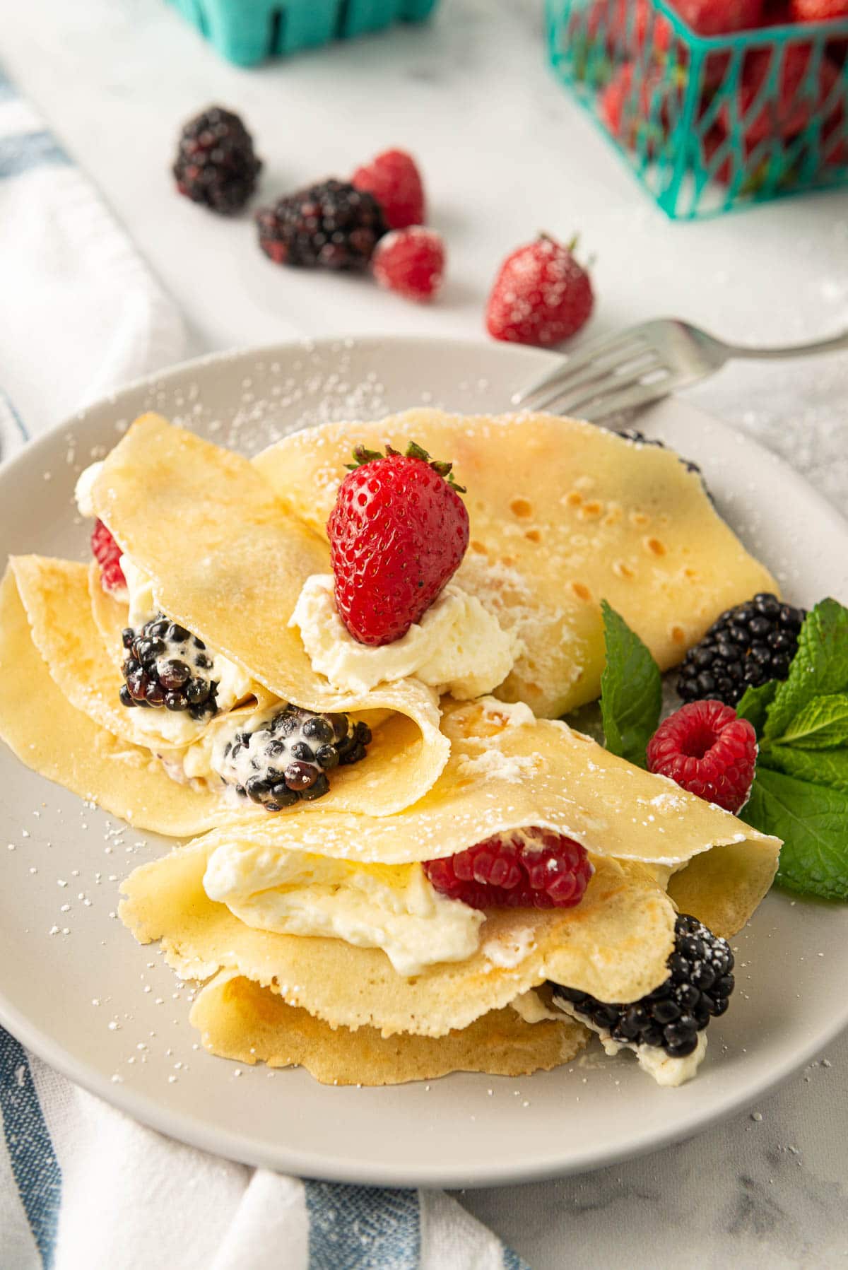 An example of French crepes folded with whipped cream and a mix of uncut berries.