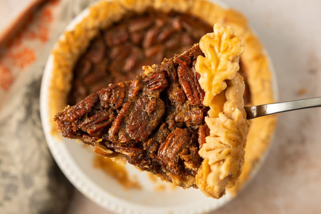 A close-up photo of a slice of pecan pie.