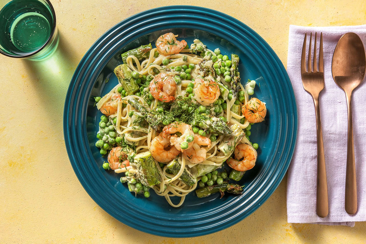 A blue plate piled high with roasted shrimp and asparagus linguine, as created by HelloFresh.