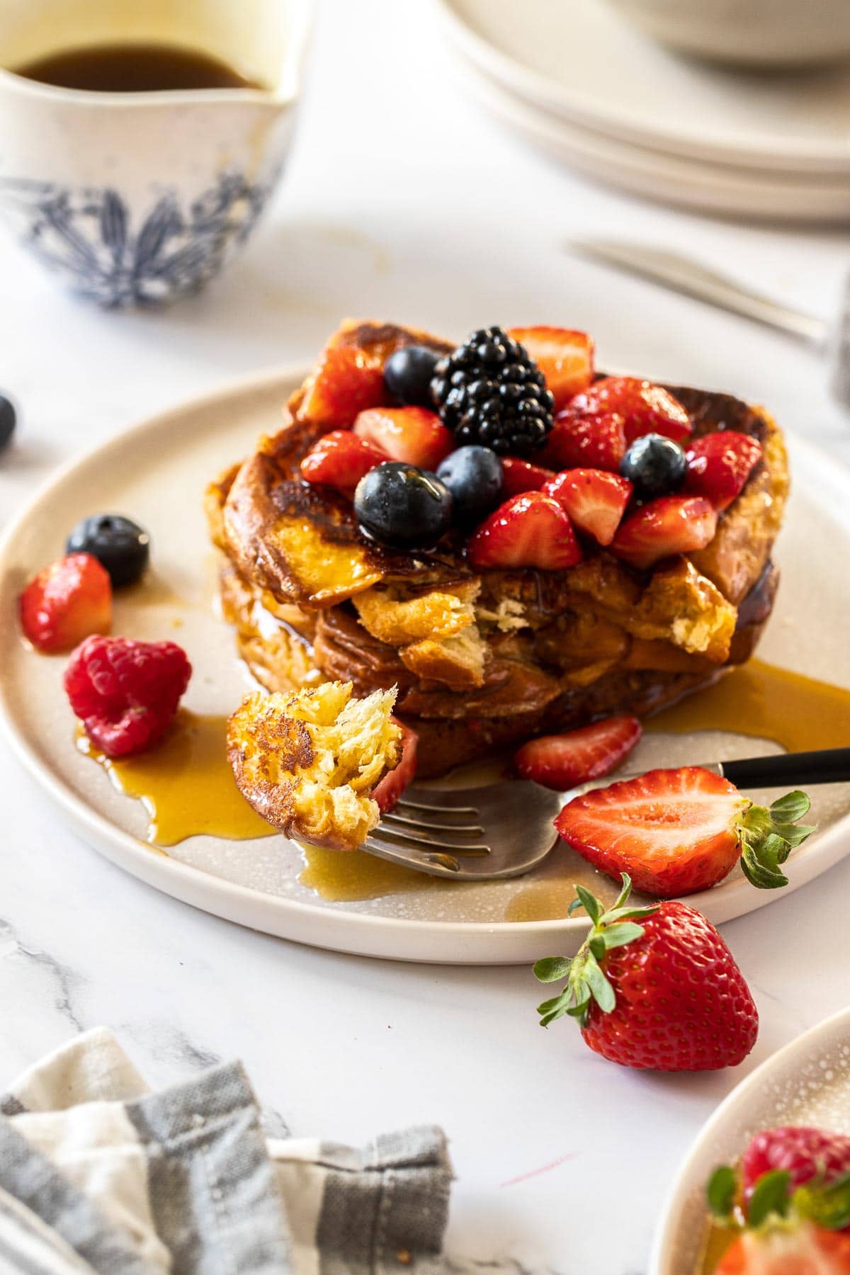 A stack of French toast with a bite cut out of them.