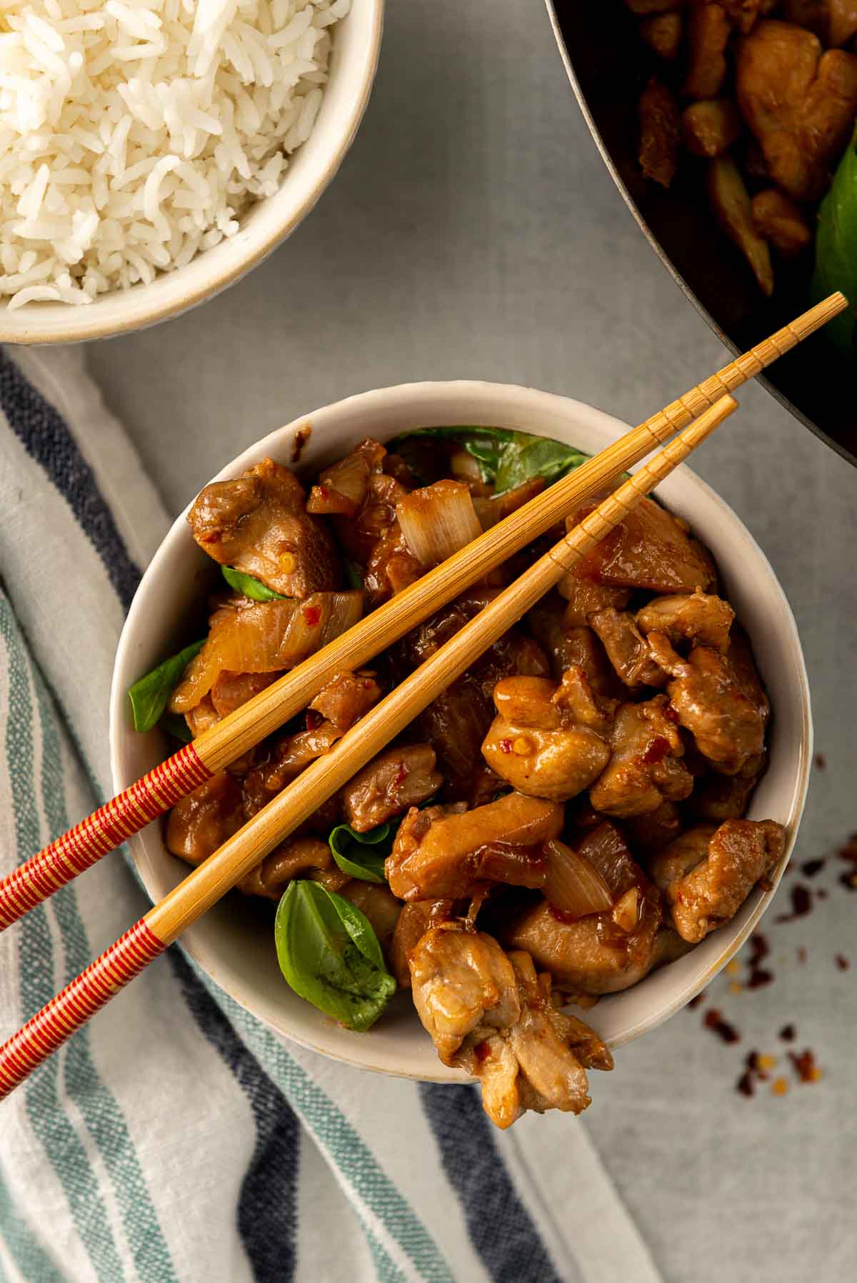 A bowl of Chinese three-cup chicken, with chopsticks on top.