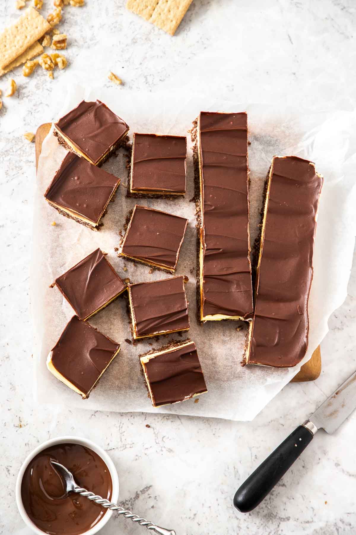 An overhead view of Nanaimo bars being sliced up into portions.