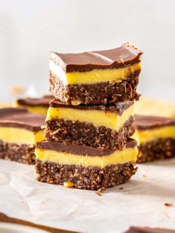 3 nanaimo bars pieces in a tower.