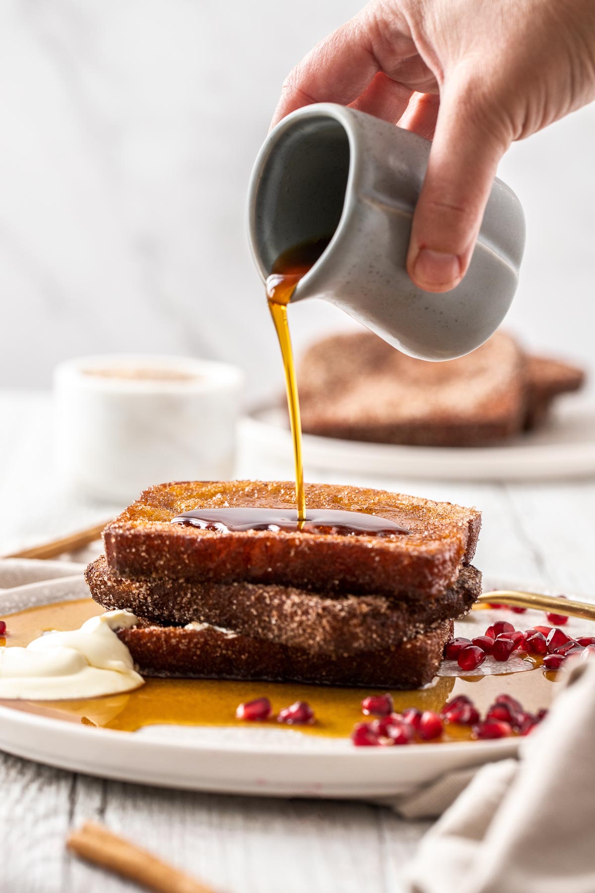 Maple syrup being poured on to a stack of Cinnamon Sugar French Toast.