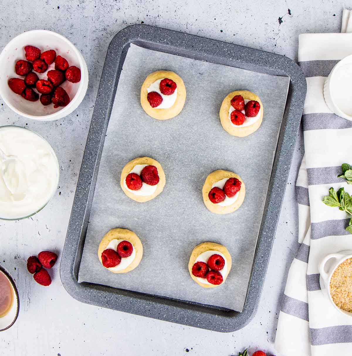 A tray of six baked raspberry cheesecake cookies.