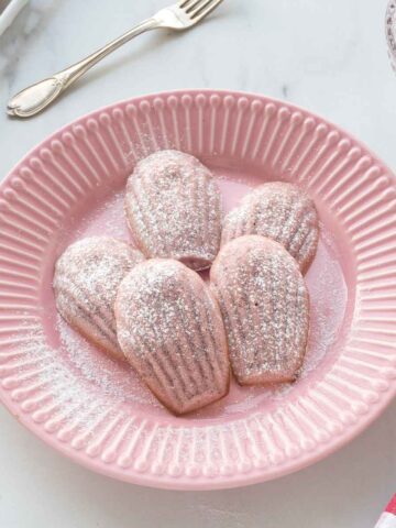 Strawberry madeleines on a pink plate.