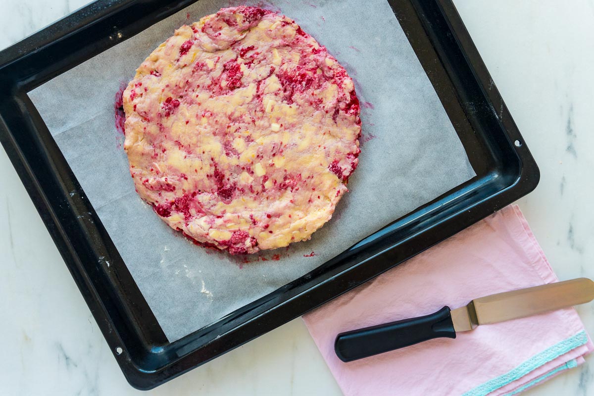 White chocolate raspberry scone dough - prepared and ready to bake - on a tray.