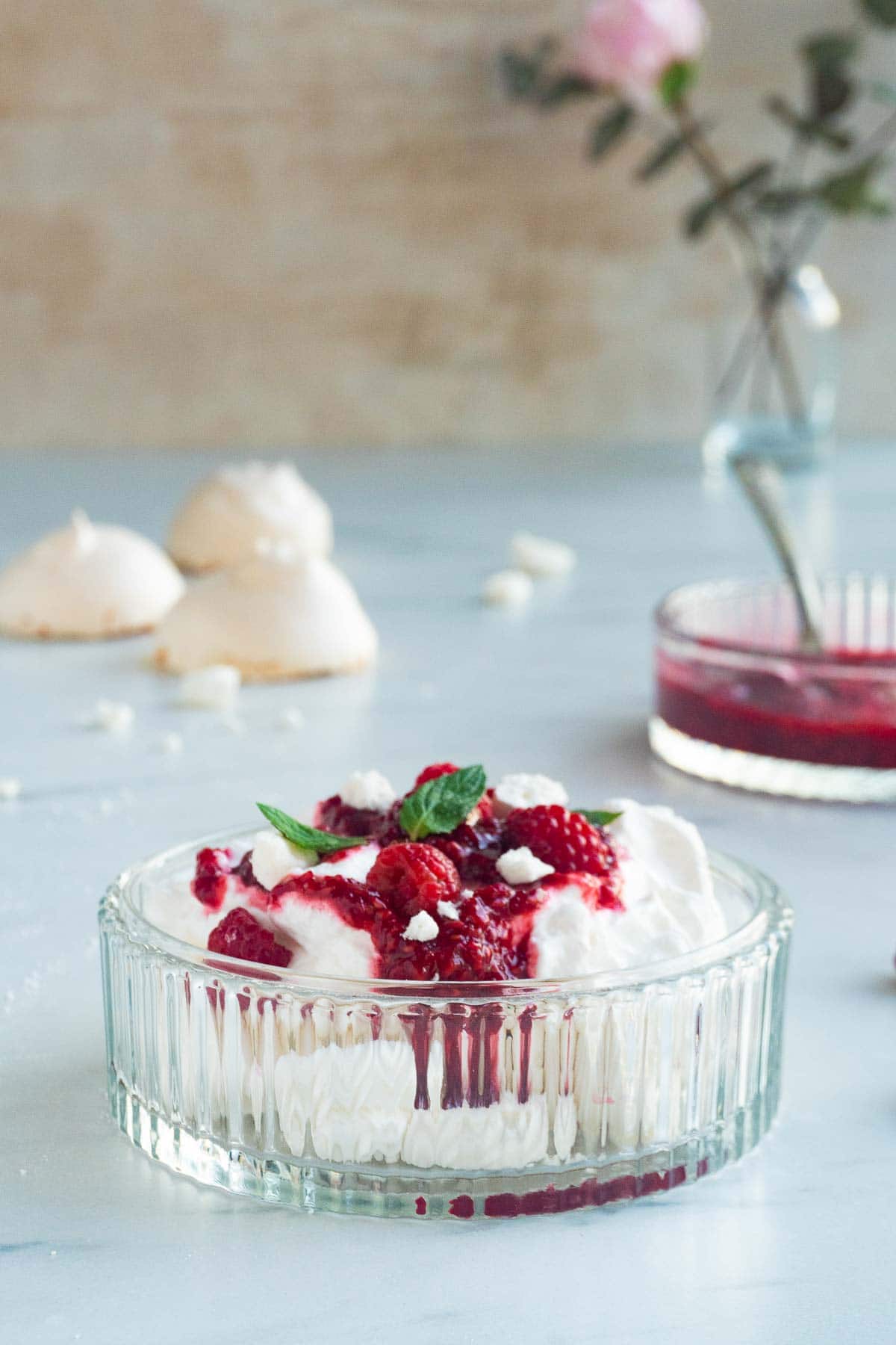 A side view of a Raspberry Eton Mess garnished with mint leaves.