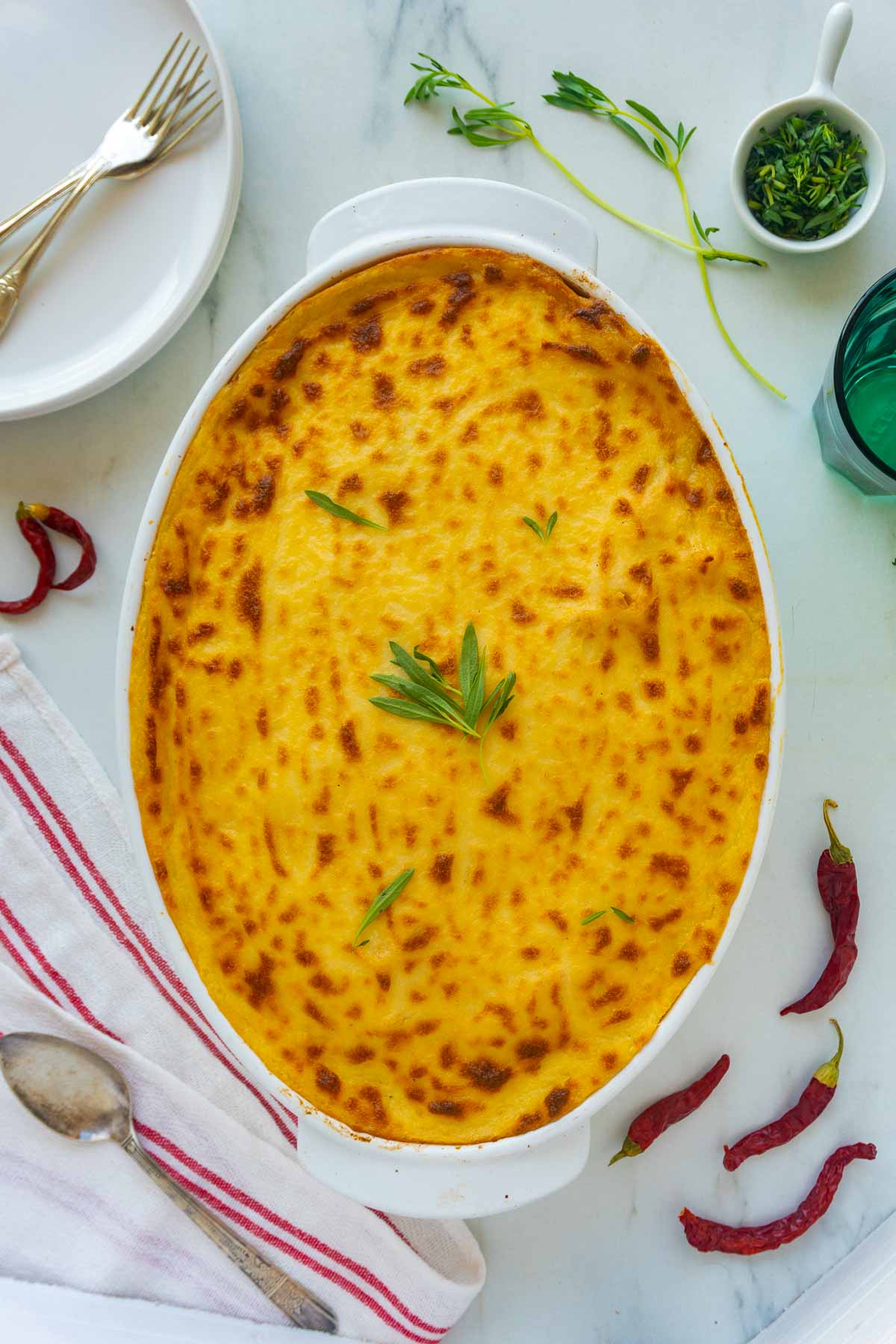 A dish of macarona bechamel surrounded by some light garnish.