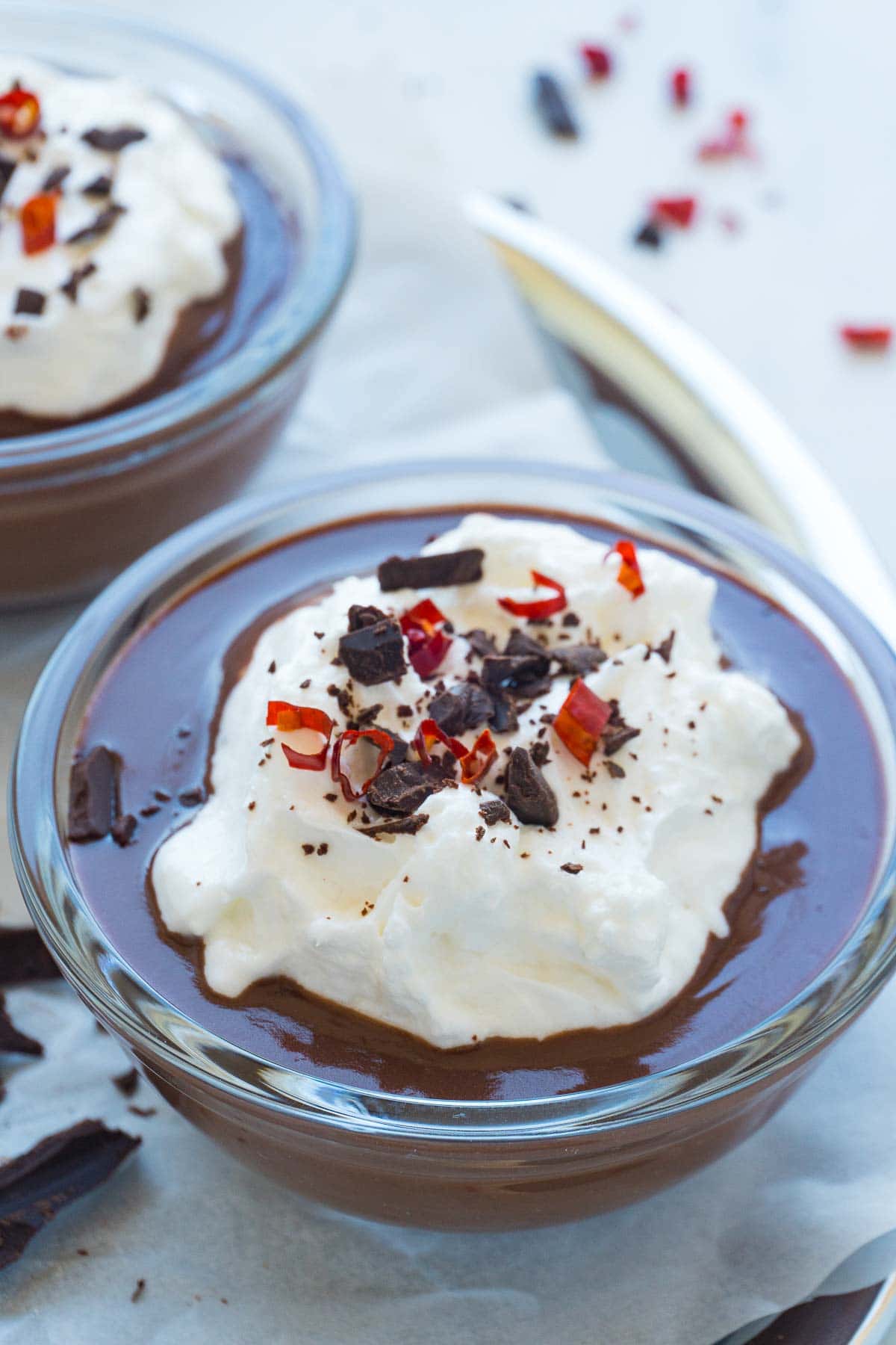 Dark chocolate pudding in a clear ramekin. The silky texture of the pudding can be seen.