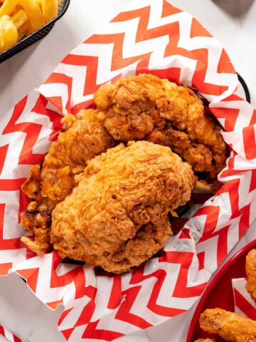 Crispy Al Baik-style Fried Chicken in a basket with red&white patterned paper in it.