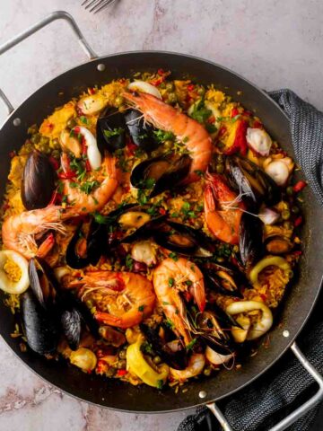 An overhead shot of a paellera filled with a beautiful seafood paella Valenciana.