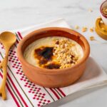 A clay pot of sutlac (baked Turkish rice pudding) decorated with hazelnuts.
