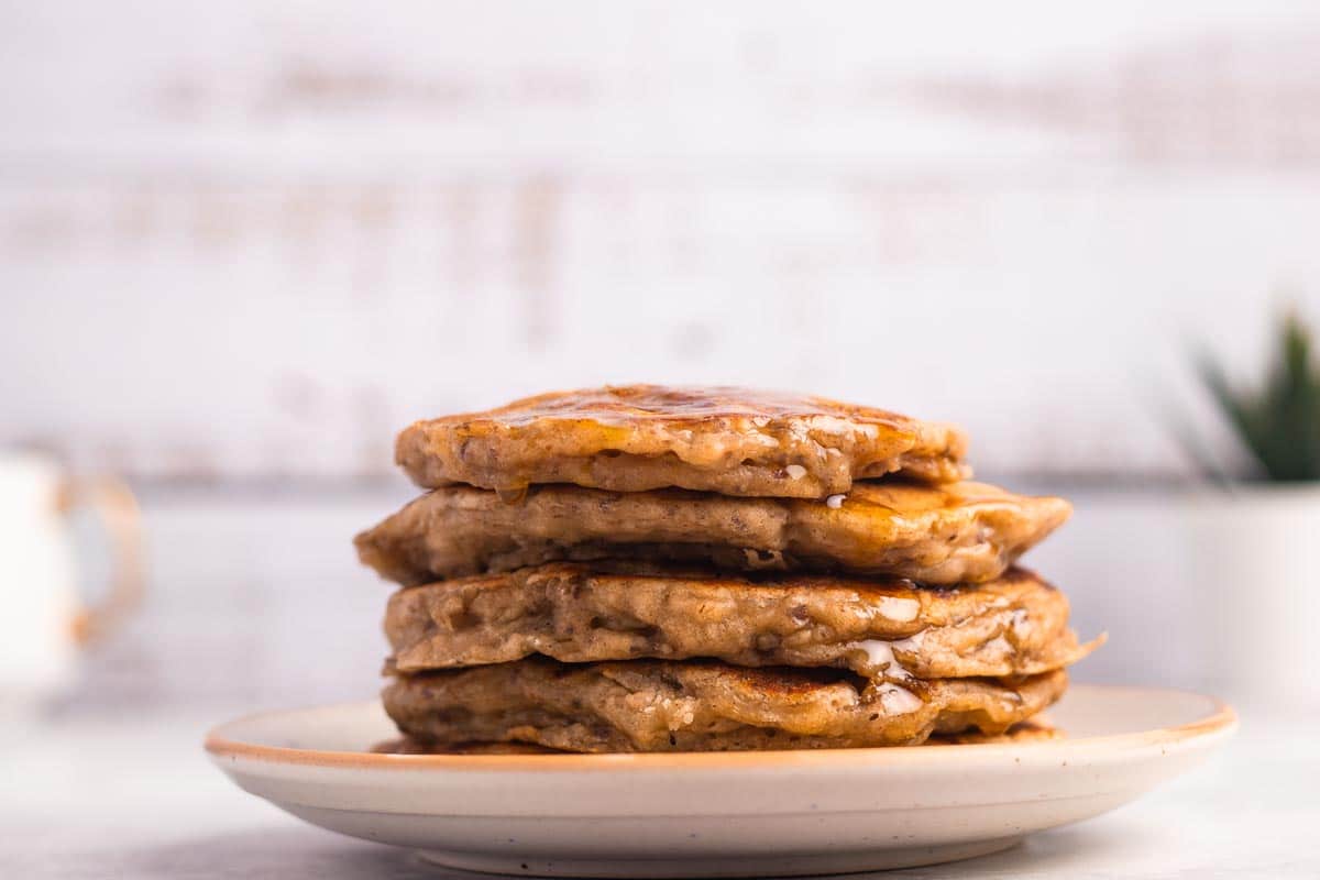 A stack of vegan-friendly banana pancakes on a white plate.