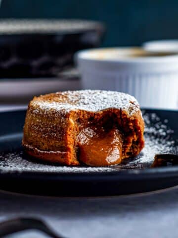 A Dulce de Leche Lava cake that has been sliced into. The molten center is oozing out.