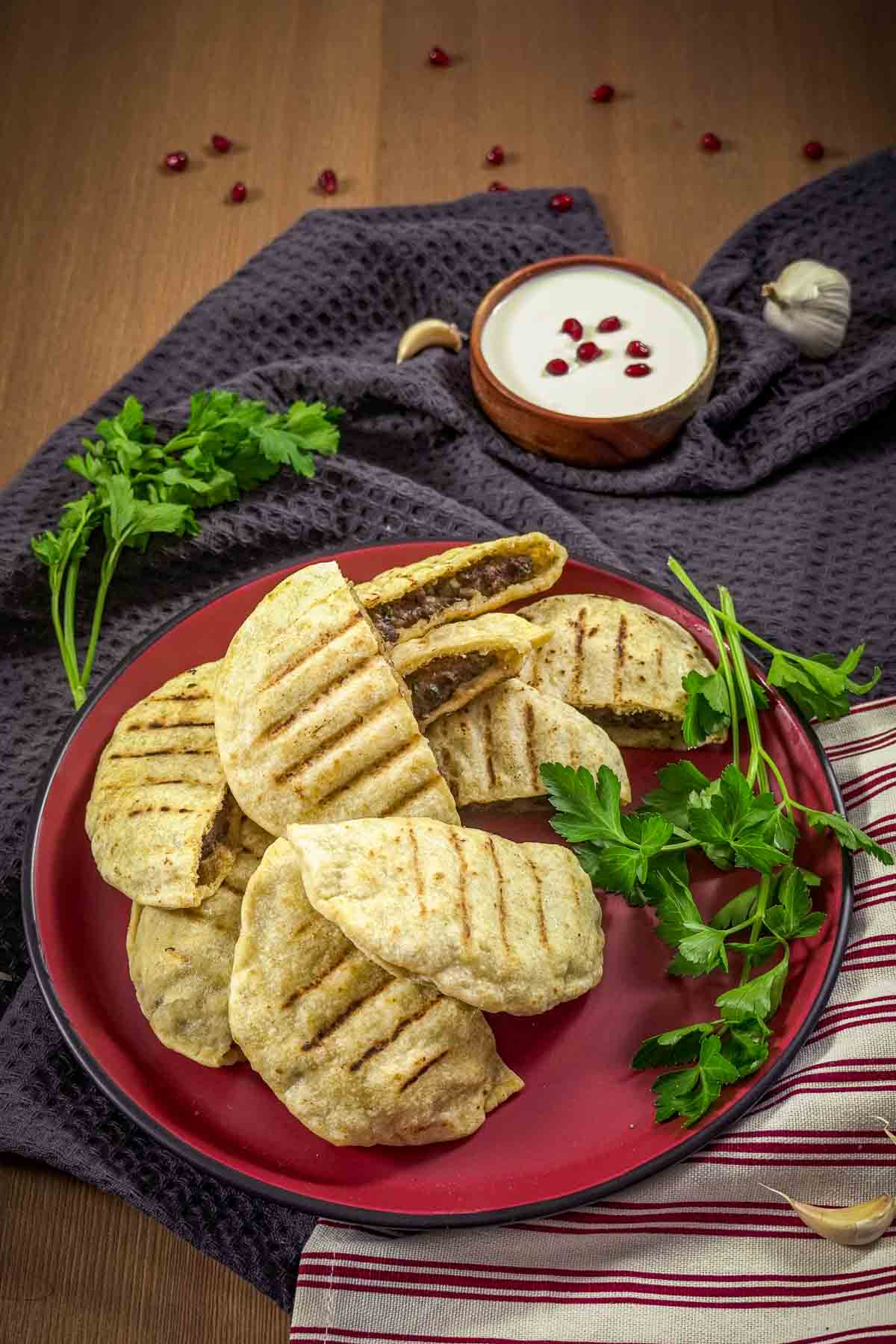 Several Lebanese stuffed pita sandwiches on a red tray.