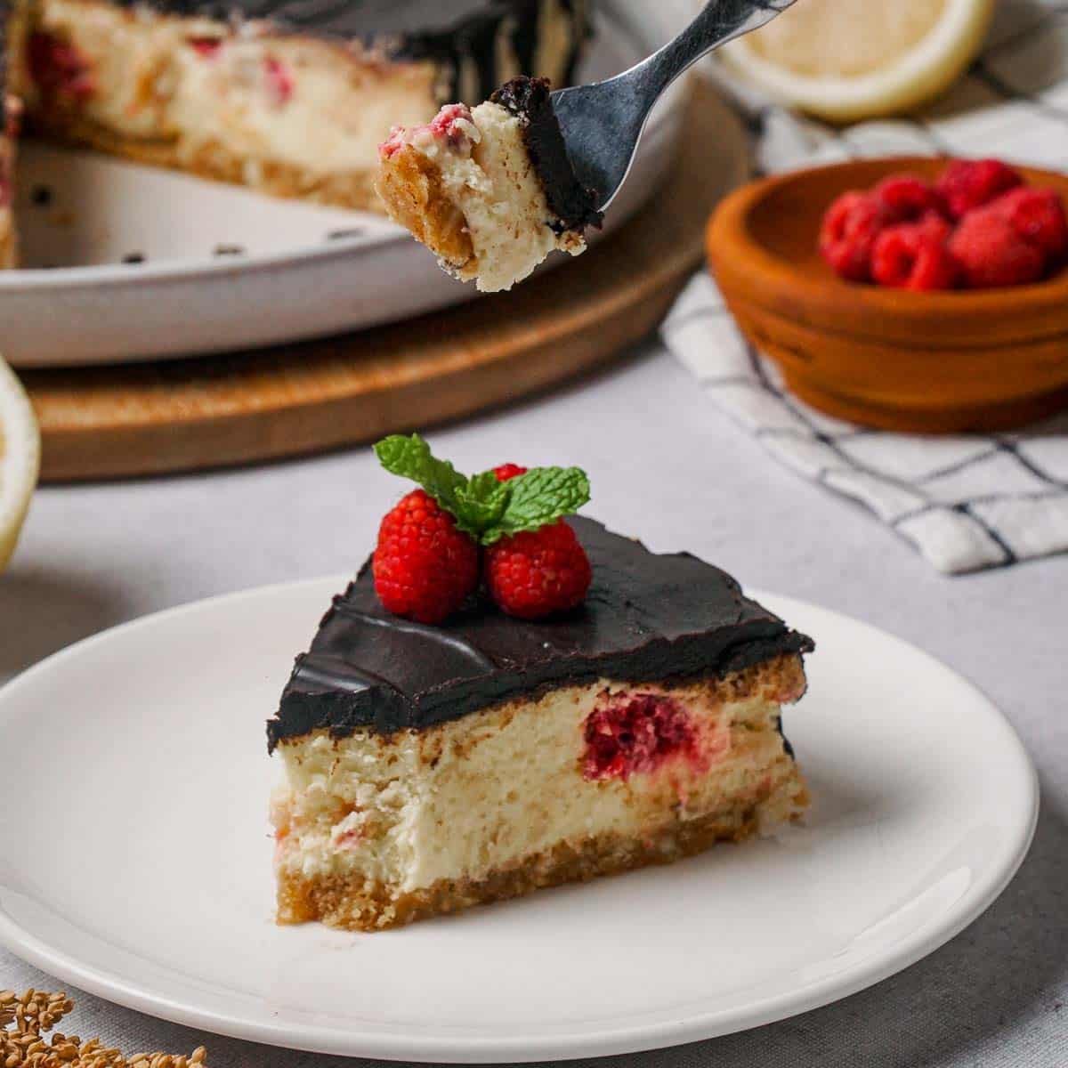 A slice of chocolate raspberry cheesecake on a white plate. 