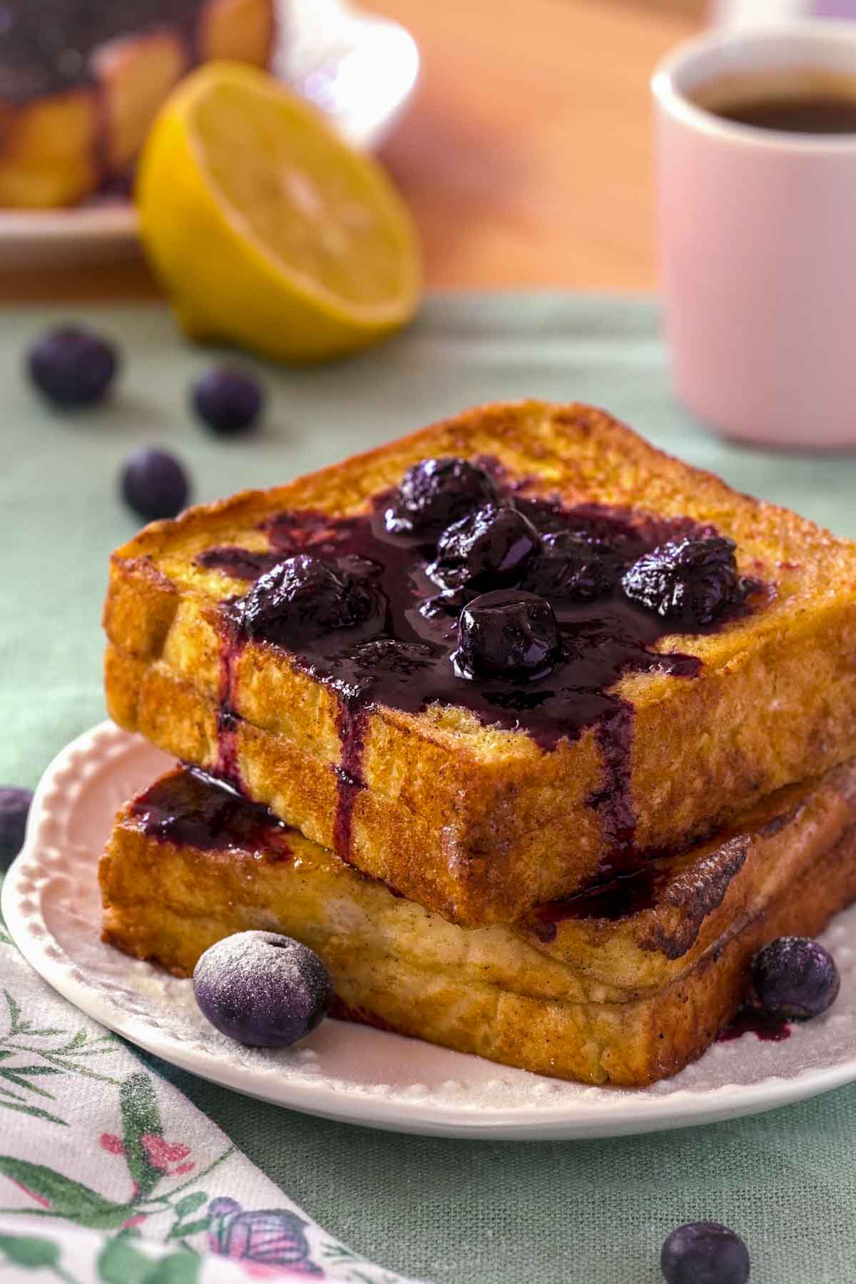 Lemon Blueberry stuffed French toast, topped with blueberry compote o na white plate.