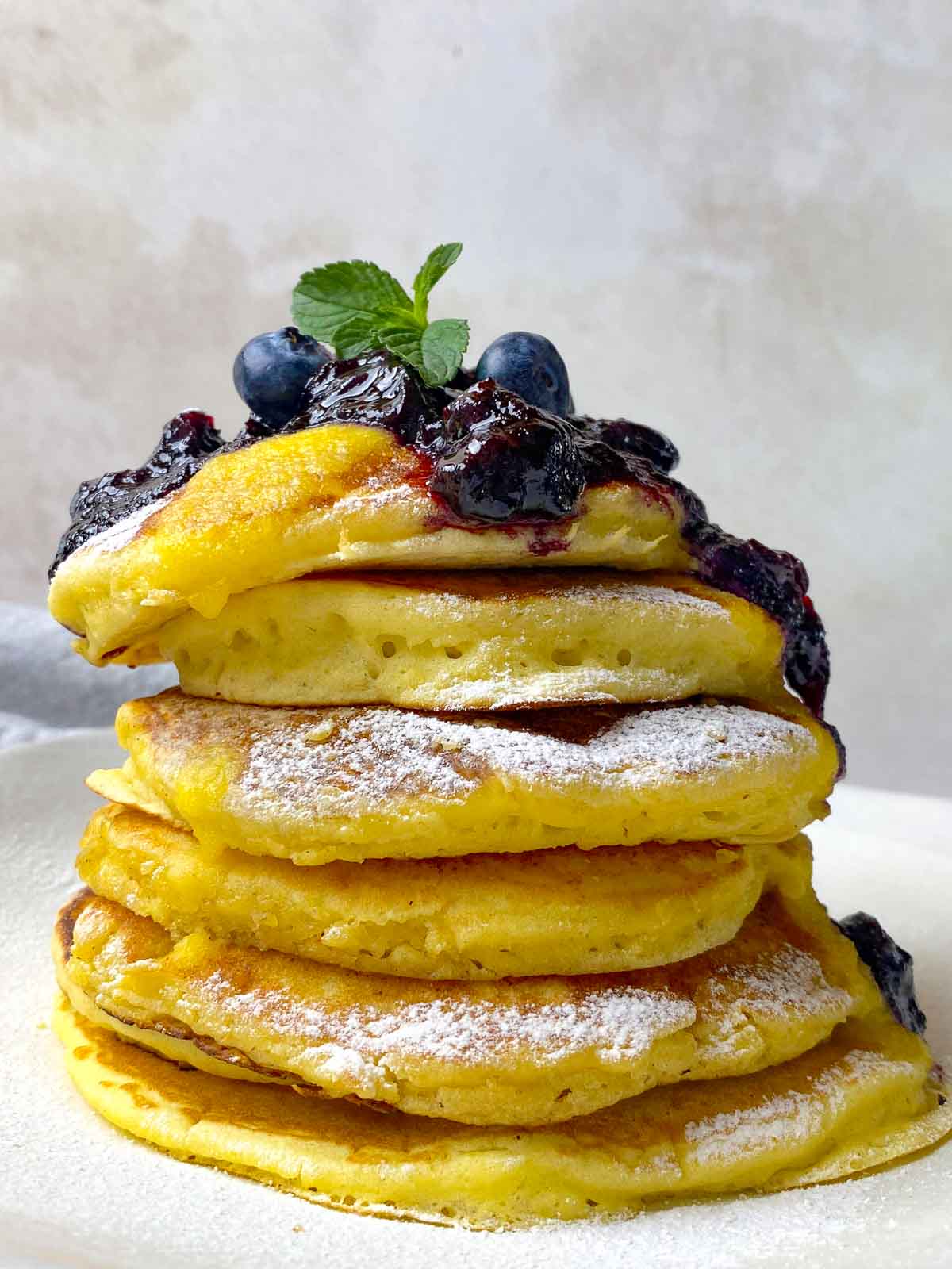 Fluffy and thick lemon ricotta pancakes in a tall stack.