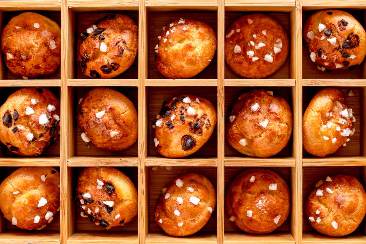 Several chouquettes placed in a wooden compartment box.
