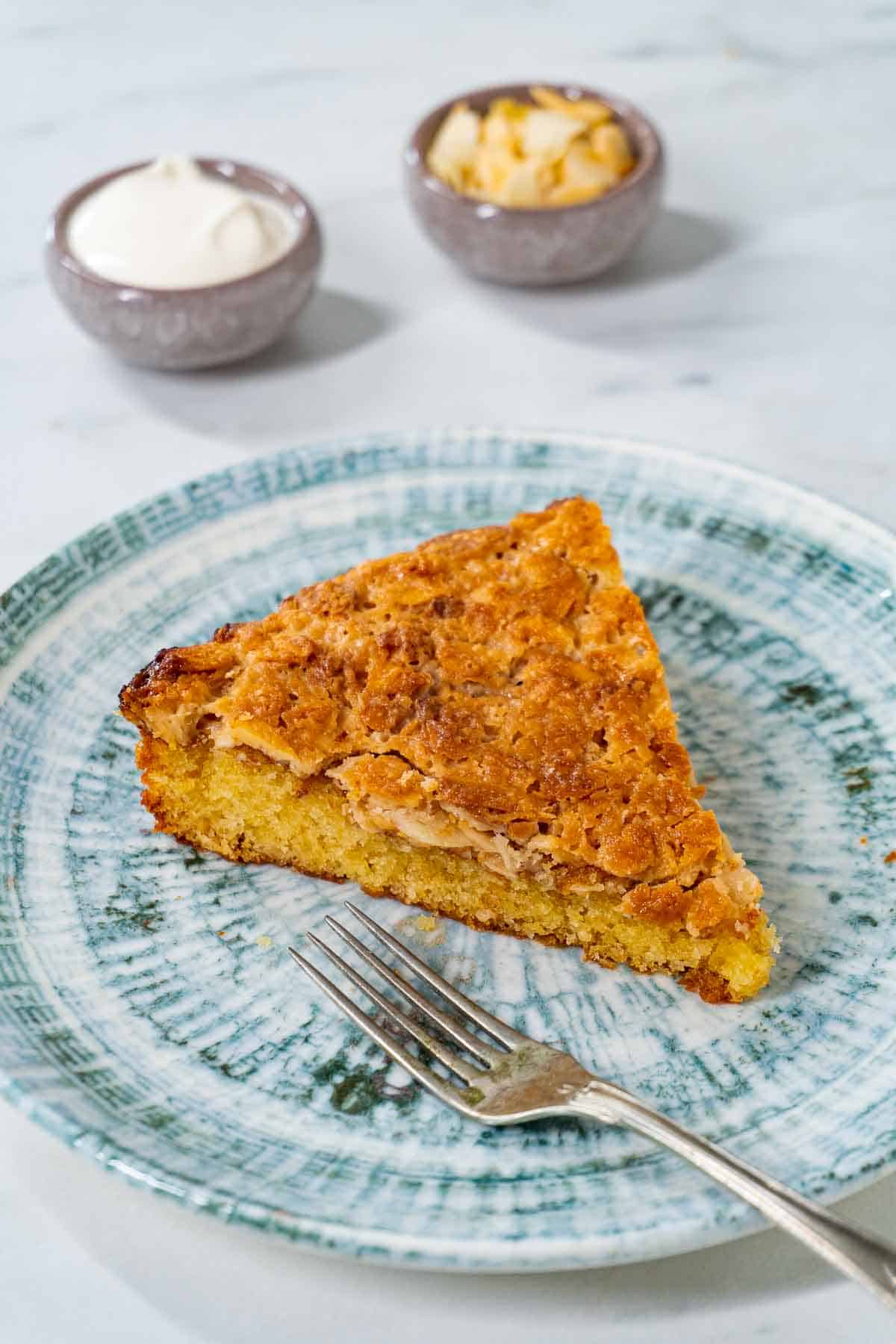 Swedish almond cake on a plate with a fork next to it.