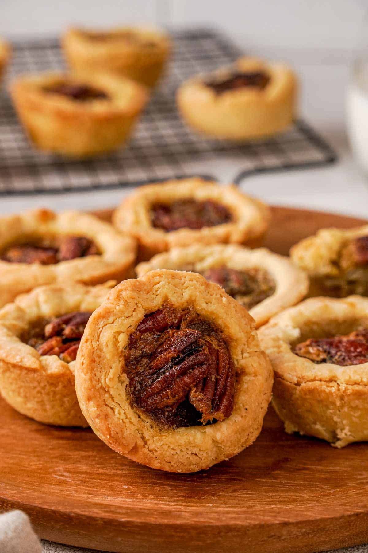 A butter tart propped up against under tarts to show the filling.