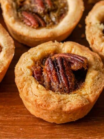 A close-up of a Canadian butter tart with pecans.