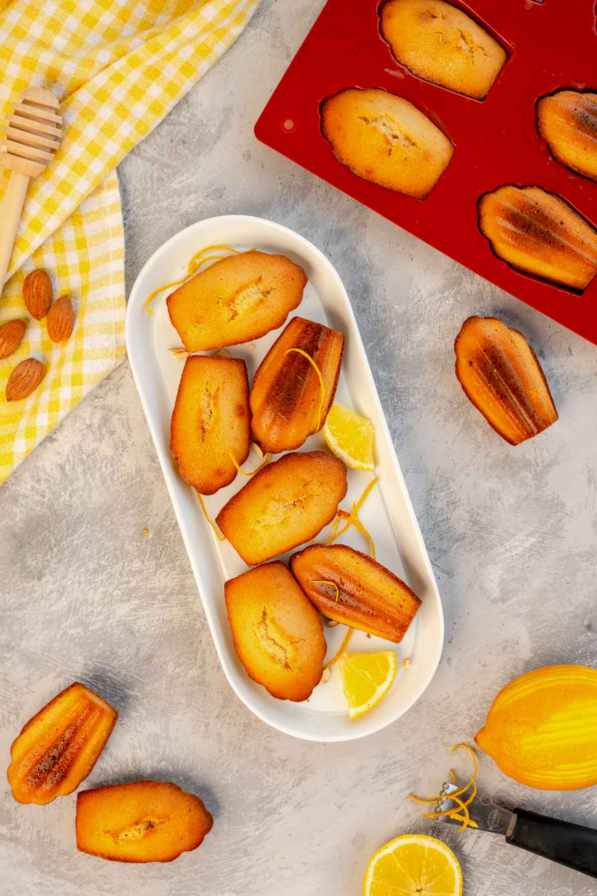 Honey Madeleines and lemon wedges on a white tray.