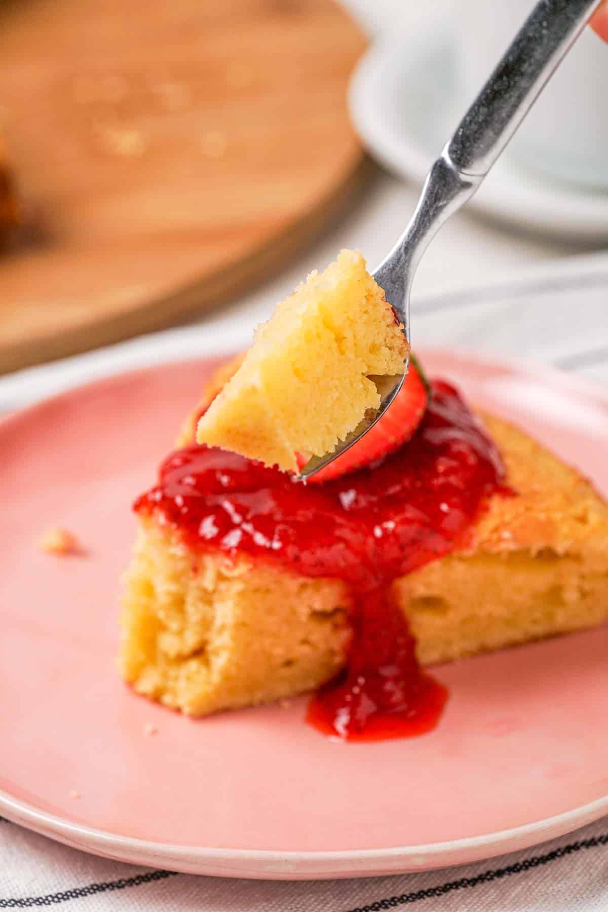 A forkful of cheesecake made from cottage cheese. The slice of cheesecake is visible in the background.