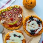 Top down shot of three halloween pizzas - each one is decorated as a different monster.