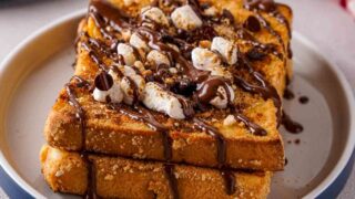 Two slices of S'mores French Toast on a white and blue dish.