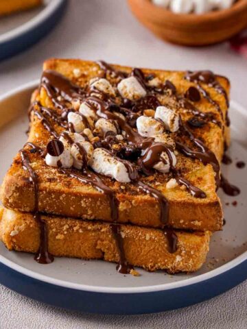 Two slices of S'mores French Toast on a white and blue dish.