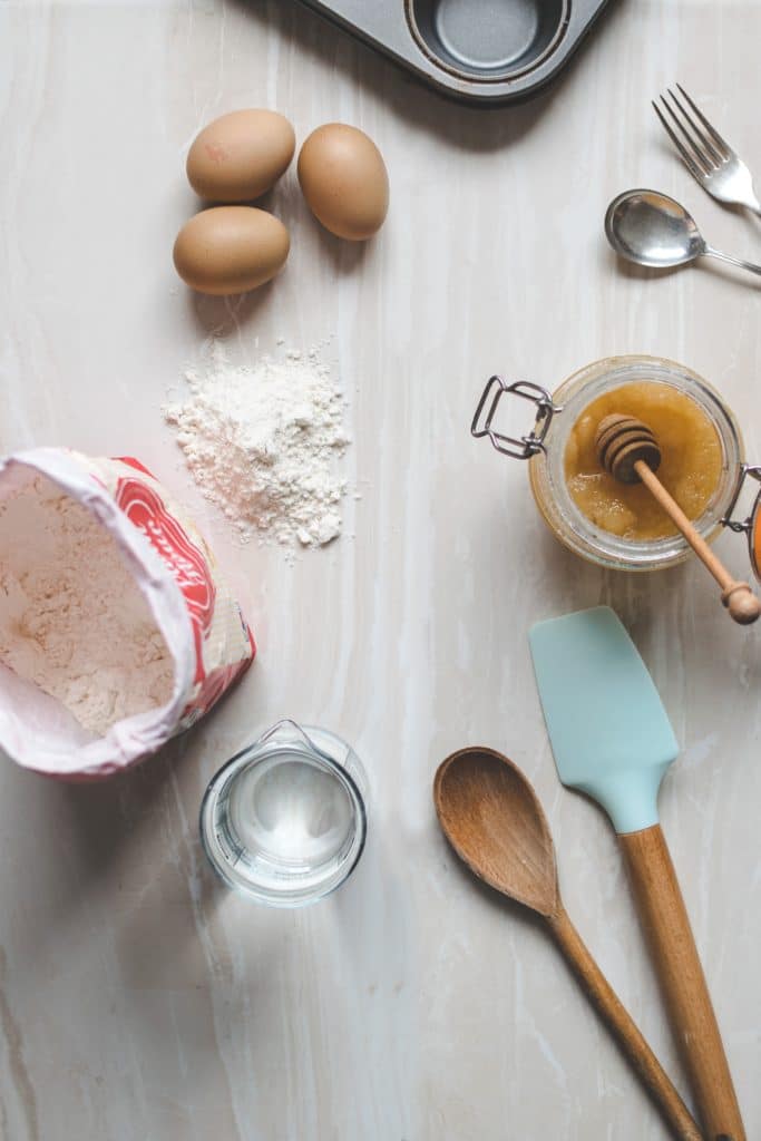 An overhead photo of baking utensils, honey and flour. 