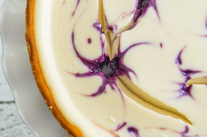 A close-up photo of a Blueberry Swirl Cheesecake, focusing on a gorgeous blueberry swirl.